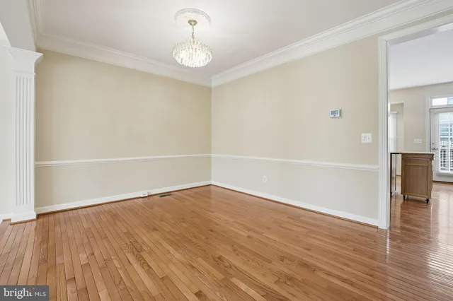an empty room with wooden floor and window