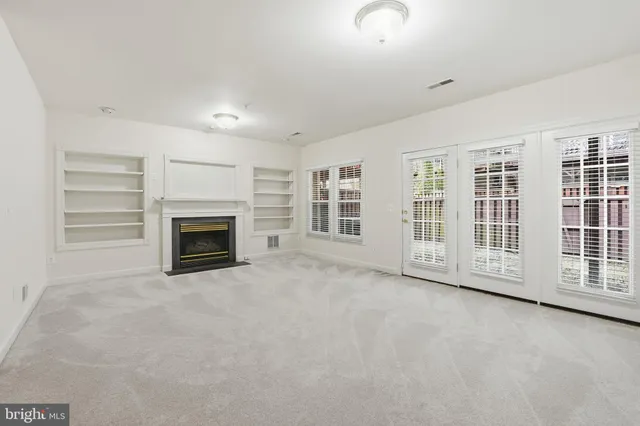 a view of an empty room with a fireplace and a window