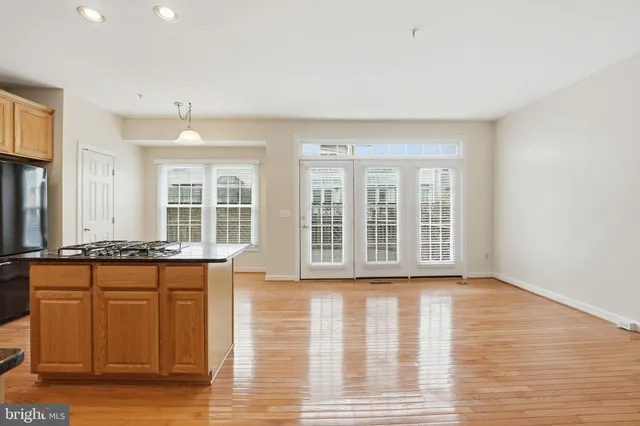 a view of a kitchen with stainless steel appliances granite countertop a stove and a wooden floors