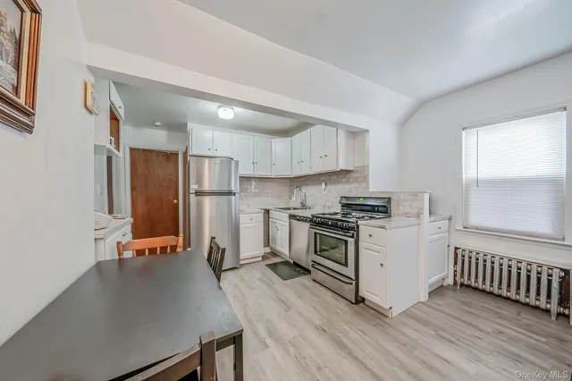 a kitchen with wooden floor and a stove top oven