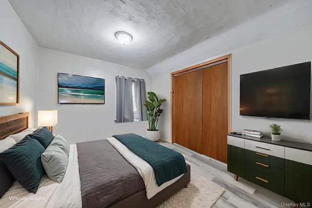 a bedroom with a bed and a flat screen tv