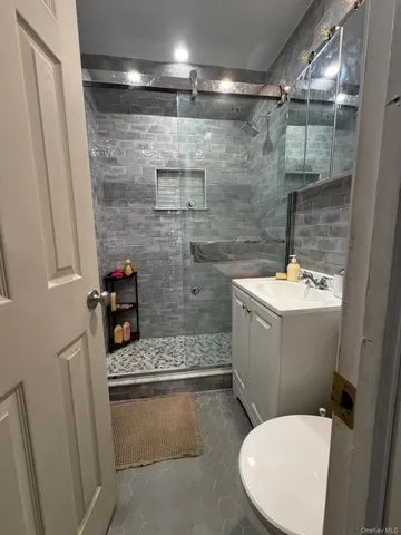 a bathroom with a sink a toilet and shower