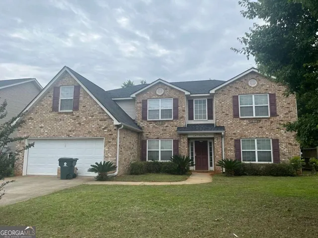 a front view of a house with a garden