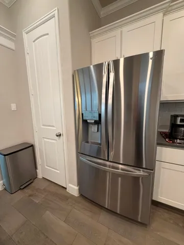 a metallic refrigerator freezer sitting in a kitchen