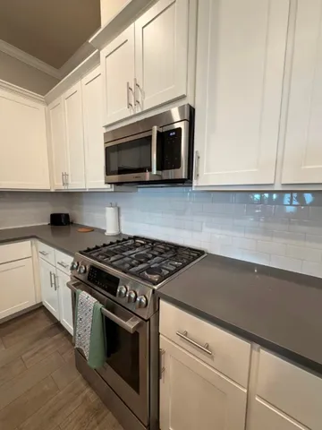 a kitchen with stainless steel appliances granite countertop a stove and a microwave