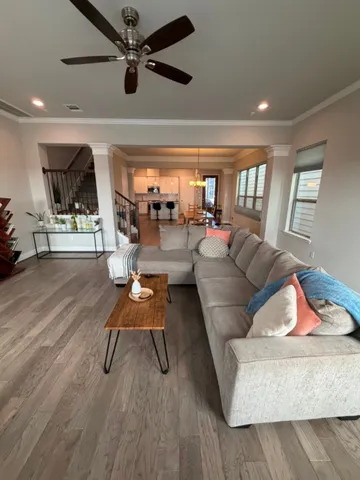 a living room with furniture and a wooden floor
