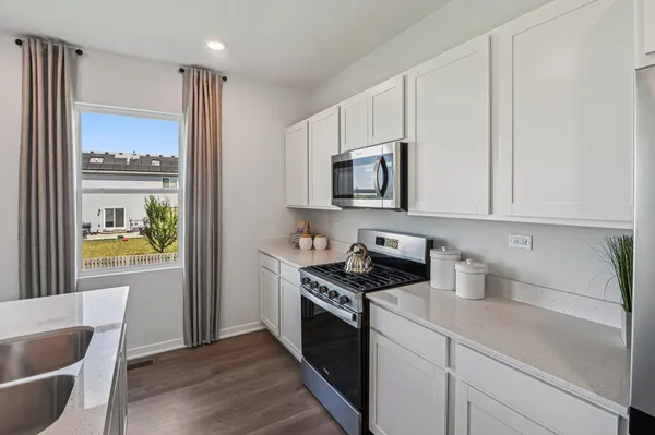 a kitchen with stainless steel appliances a white stove top oven and a sink
