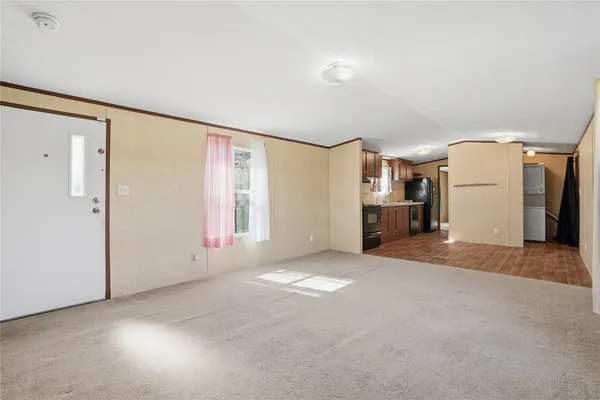 a view of empty room with furniture and refrigerator