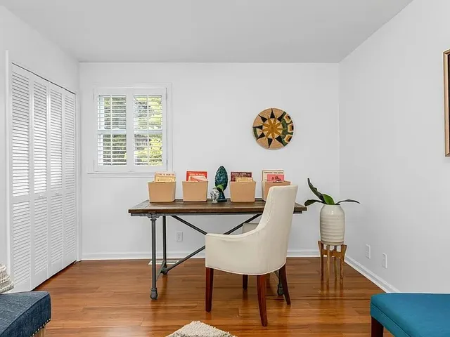 a view of a workspace with furniture and wooden floor