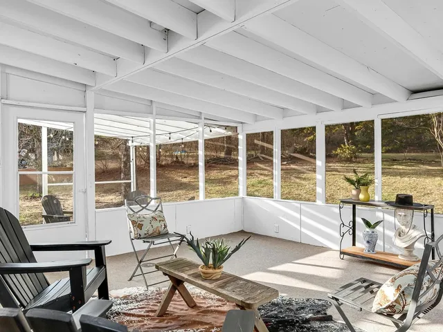 a living room filled with furniture and large windows