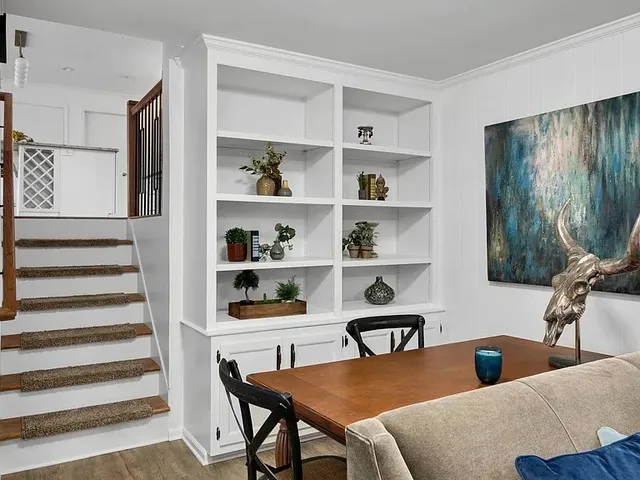 a view of a workspace with furniture and a window