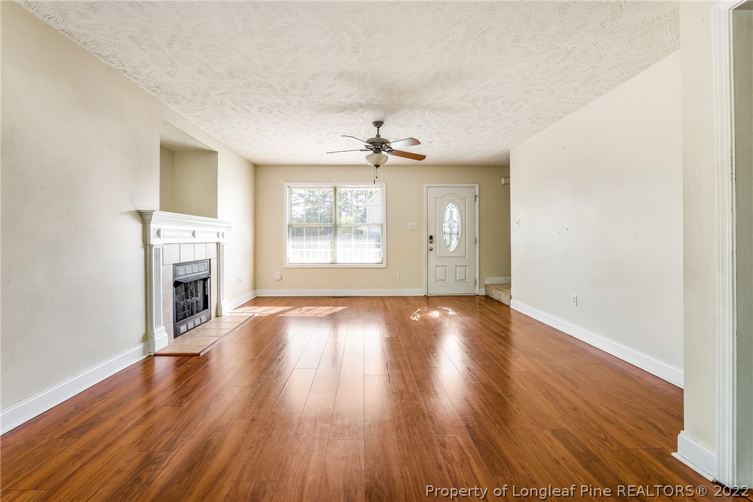 1631 Silver Ridge Court Fayetteville, NC 28304 - Photo 13 of 21 an empty room with wooden floor fireplace and windows