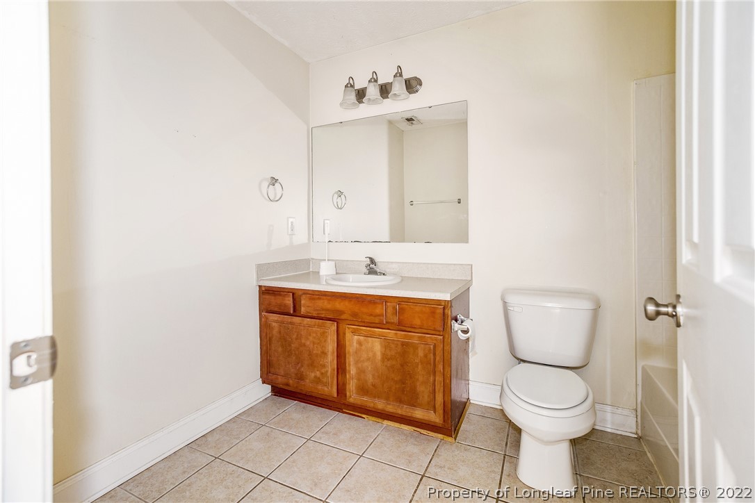 1631 Silver Ridge Court Fayetteville, NC 28304 - Photo 18 of 21 a bathroom with a toilet sink and mirror