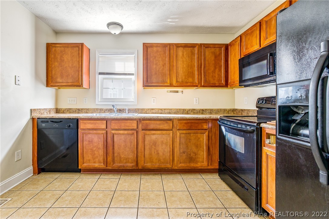 1631 Silver Ridge Court Fayetteville, NC 28304 - Photo 7 of 21 a kitchen with stainless steel appliances granite countertop a stove a sink and a microwave
