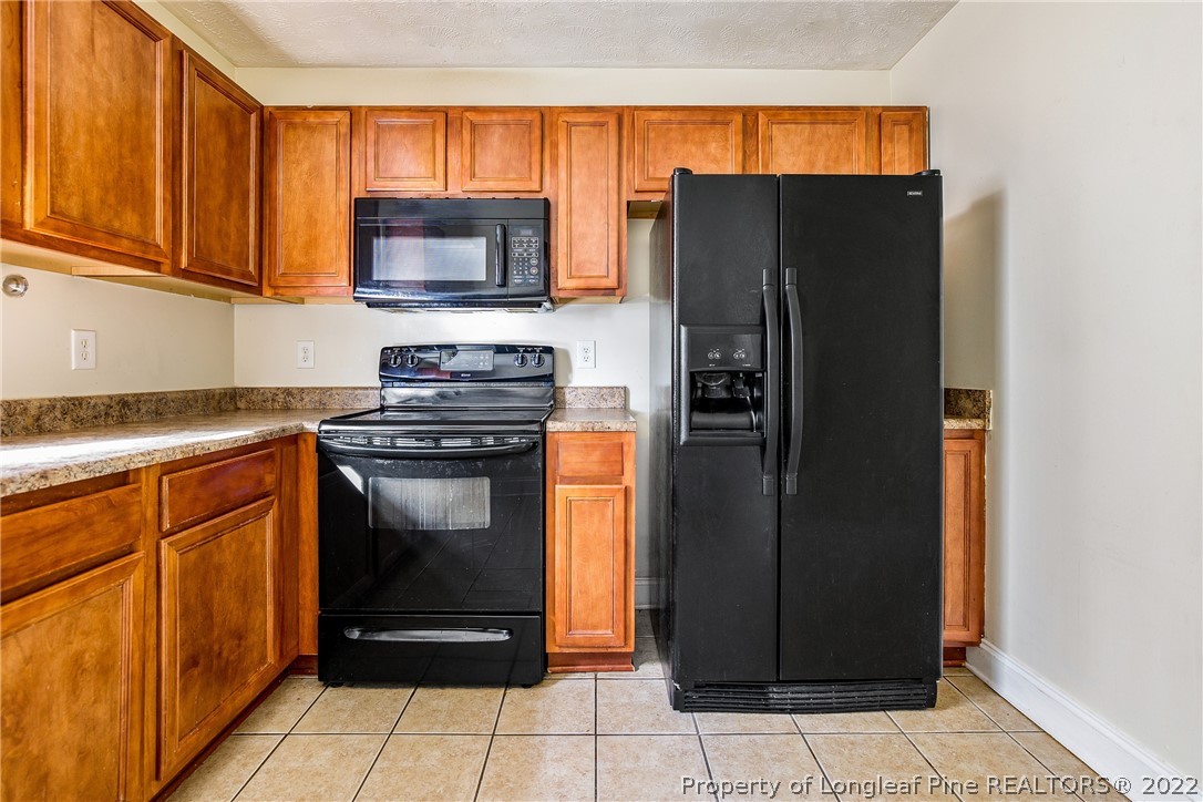 1631 Silver Ridge Court Fayetteville, NC 28304 - Photo 8 of 21 a kitchen with granite countertop a refrigerator and a stove top oven