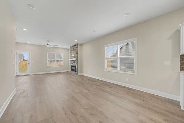 a view of empty room with wooden floor and window