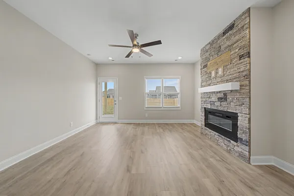 a view of an empty room with a fireplace and a window