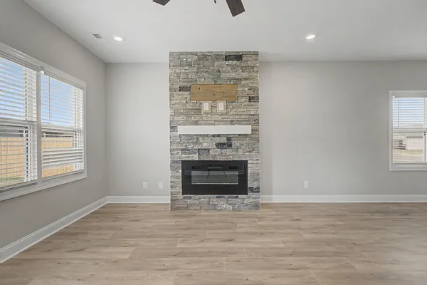 a view of an empty room with a fireplace and a window