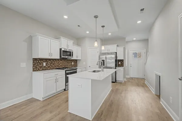a open kitchen with white cabinets and stainless steel appliances