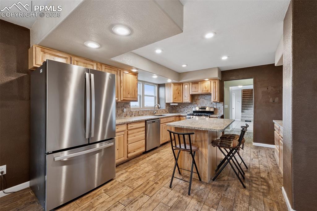 13490 Halleluiah Trail Elbert, CO 80106 - Photo 4 of 38 a kitchen with stainless steel appliances a refrigerator a stove a sink dishwasher a oven with white cabinets and wooden floor