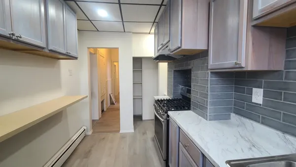 a kitchen with granite countertop a sink a stove and cabinets