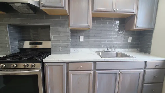 a kitchen with stainless steel appliances granite countertop a sink stove and cabinets