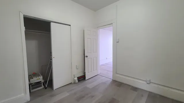an empty room with wooden floor and closet