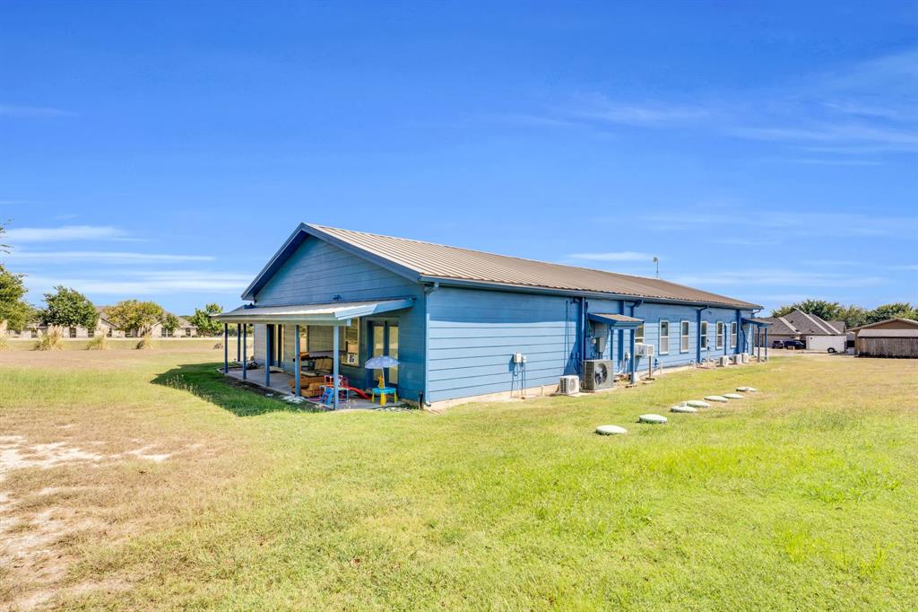3841 Ledgestone Lane Midlothian, TX 76065 - Photo 15 of 21 Back of house with a lawn, a patio area, and a metal roof