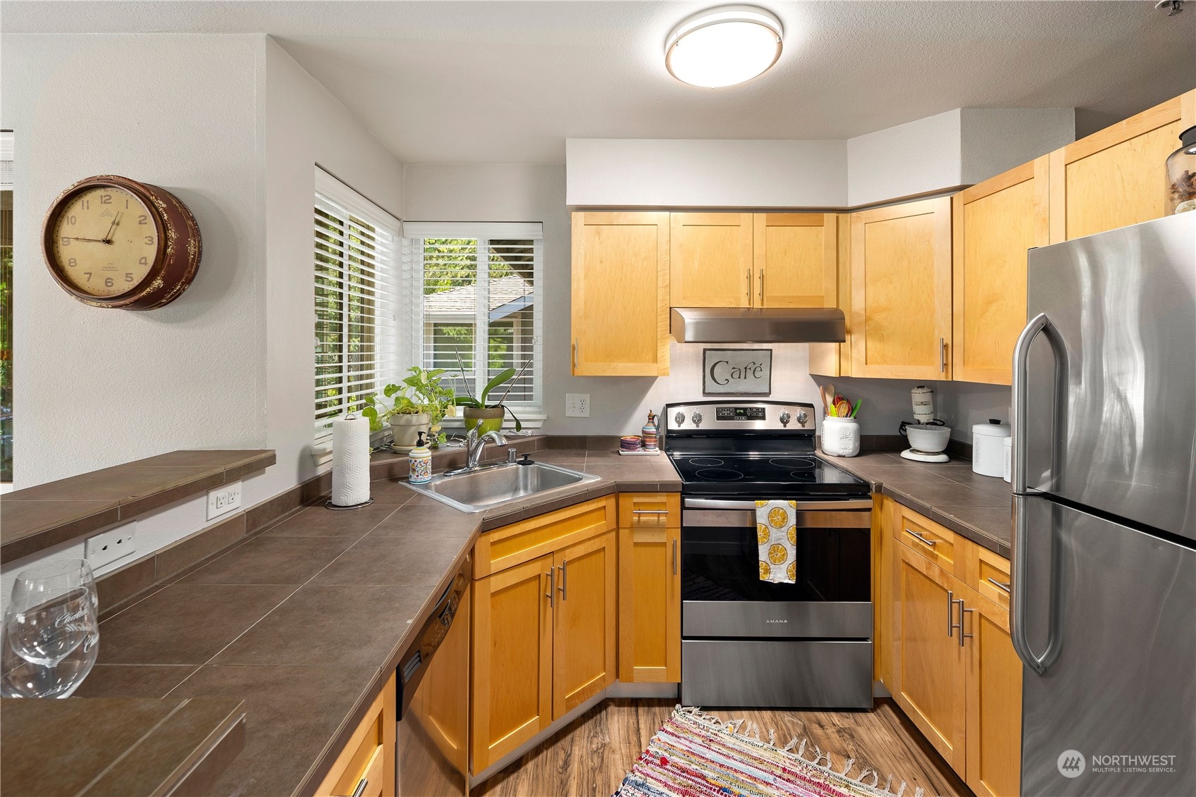 3914 243rd Place Southeast, Unit L401 Bothell, WA 98021 - Photo 12 of 25 a kitchen with stainless steel appliances granite countertop a stove a refrigerator and a microwave
