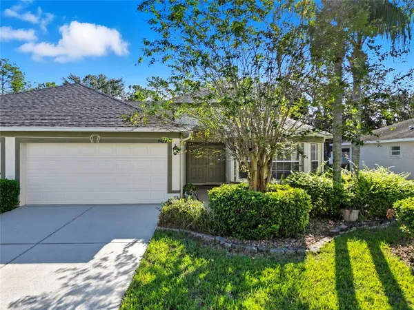 a front view of a house with a yard garage and outdoor seating