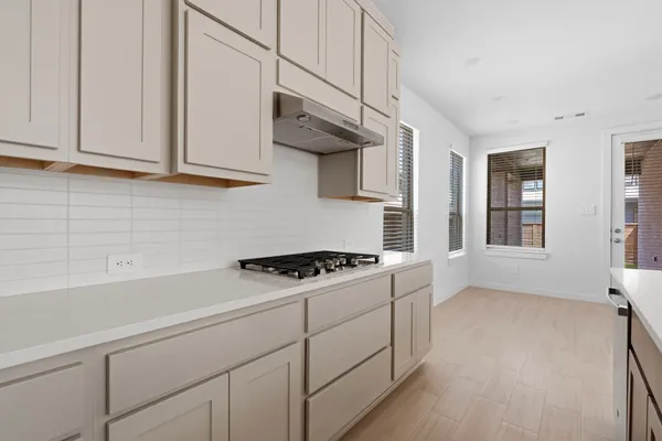 a kitchen with white cabinets and a stove top oven