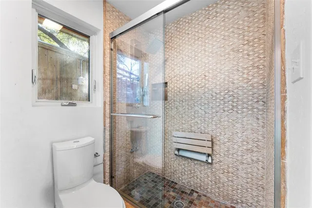 a bathroom with a toilet and a shower