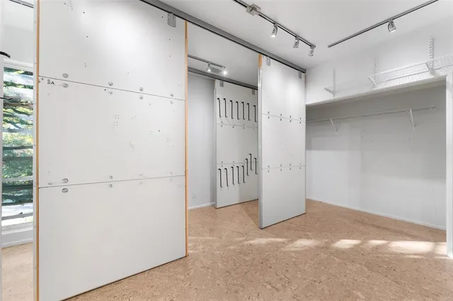 a view of a refrigerator in kitchen and white cabinets