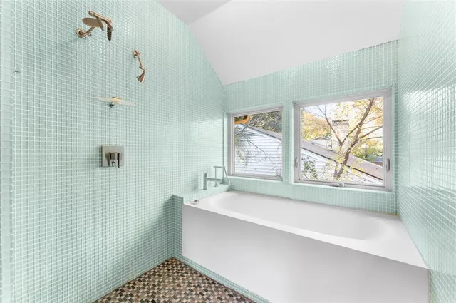 a bathroom with a bathtub and next to a window