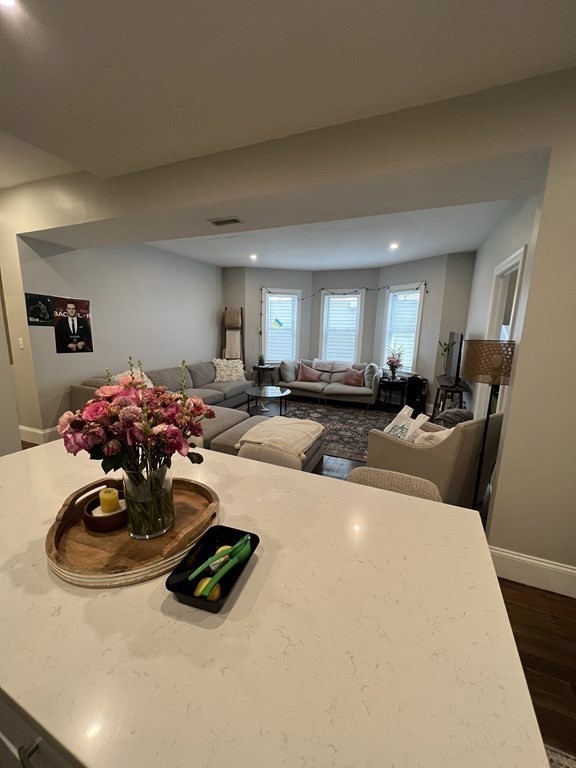 209 East Cottage Street, Unit 1 Boston, MA 02125 - Photo 2 of 10 a living room with furniture and a chandelier