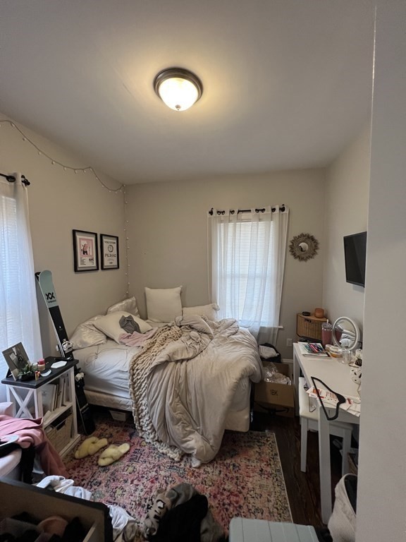 209 East Cottage Street, Unit 1 Boston, MA 02125 - Photo 4 of 10 a bedroom with a bed and wooden floor
