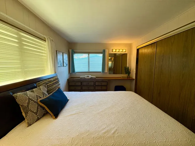 a bedroom with a bed window and dresser