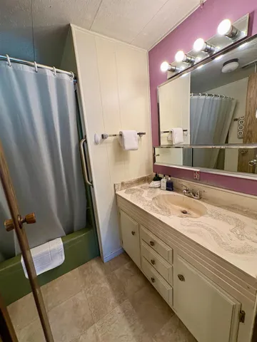 a bathroom with double vanity and a mirror