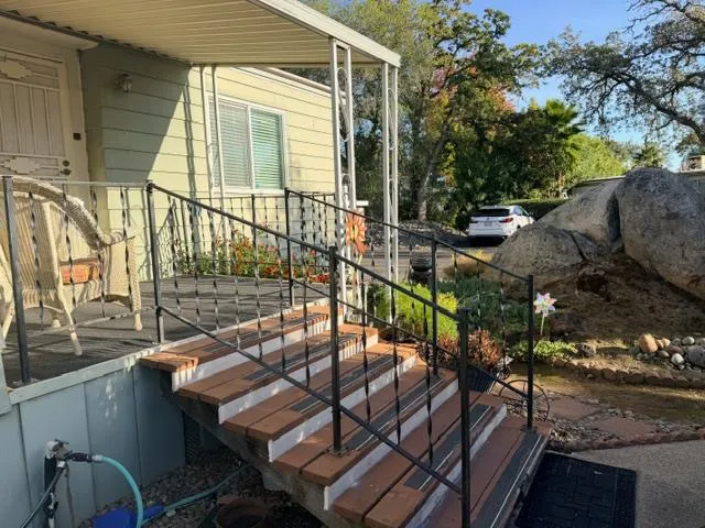 a view of a patio with table and chairs with wooden floor and fence