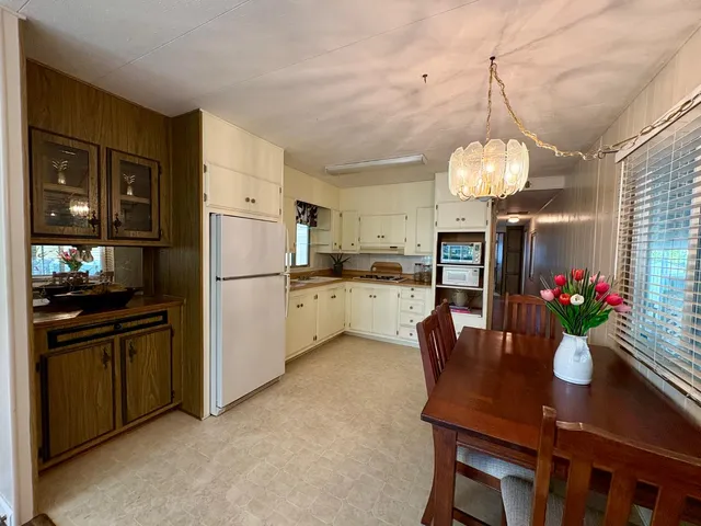a kitchen with refrigerator cabinets dining table and chairs