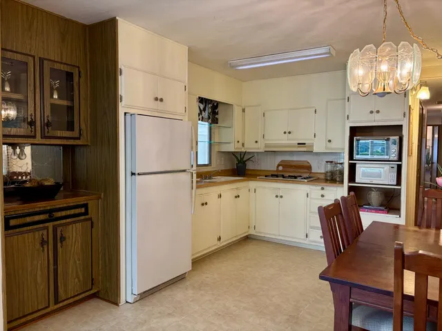 a kitchen with cabinets a refrigerator and a stove top oven