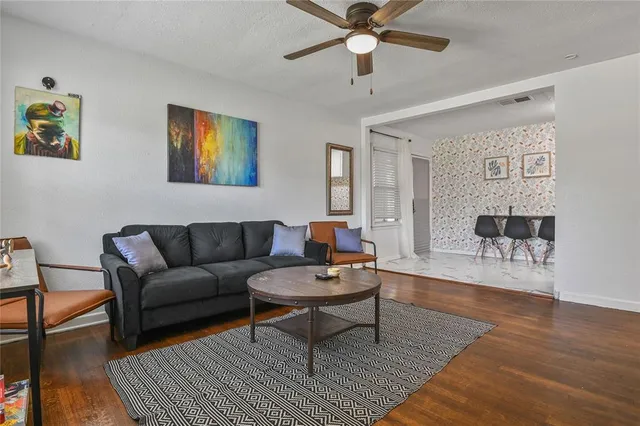 a living room with furniture and a wooden floor