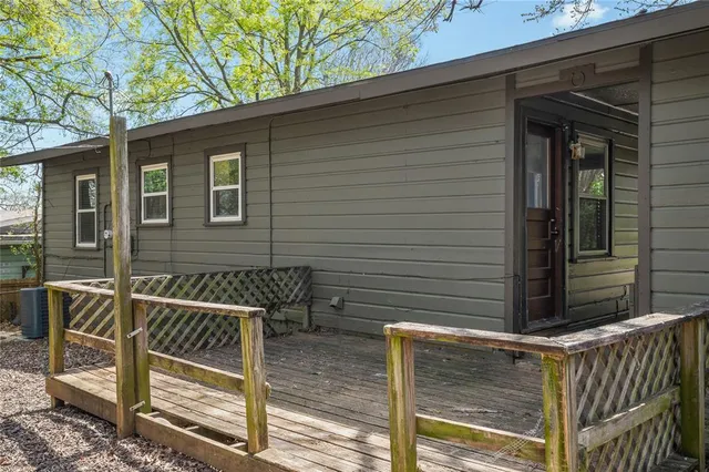 a view of house with a fence and a tree