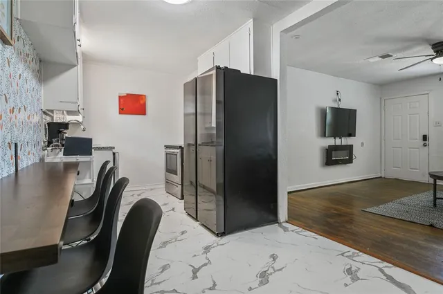 a kitchen with kitchen island a refrigerator stove and sink