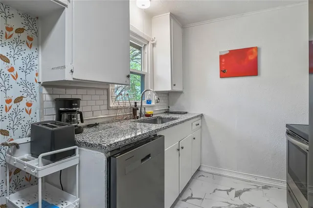a kitchen with stainless steel appliances granite countertop a sink and a refrigerator