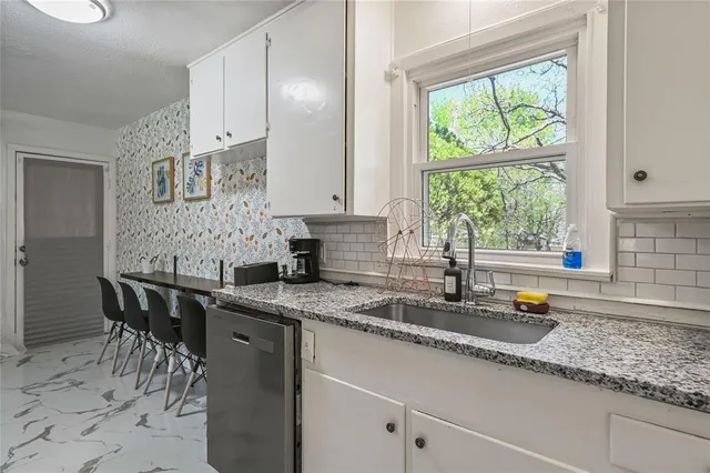 a kitchen with stainless steel appliances granite countertop a sink and a white cabinets