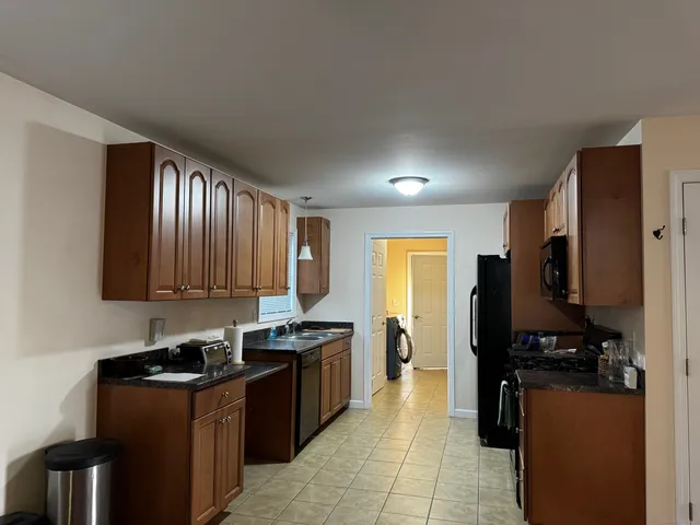 a kitchen with stainless steel appliances granite countertop a stove a refrigerator a sink and dishwasher
