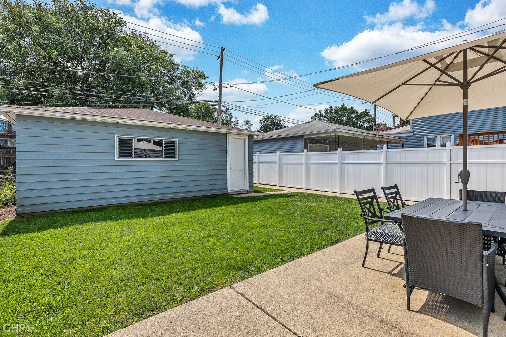 4841 West Berenice Avenue Chicago, IL 60641 - Photo 20 of 34 a view of a backyard with table and chairs under an umbrella