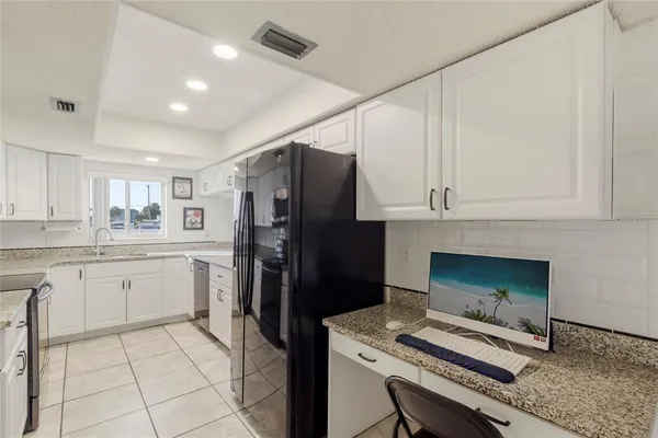 a kitchen with a sink and steel appliances