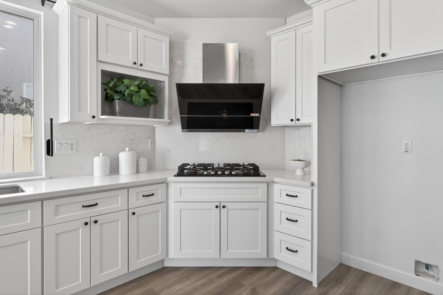 6217 Jefjen Way Elk Grove, CA 95757 - Photo 21 of 58 a kitchen with white cabinets and a stove with wooden floor